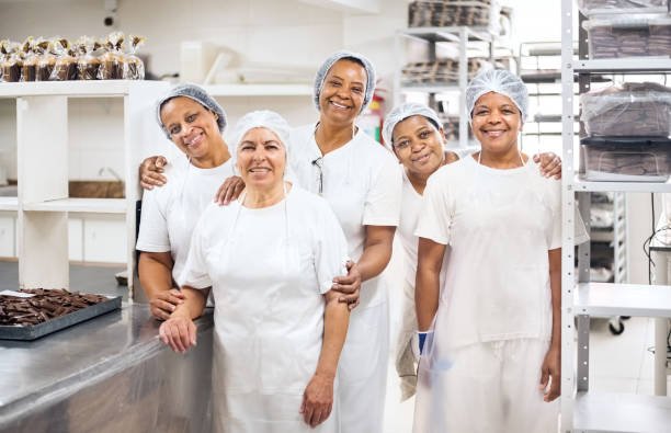 portrait of group of senior female confectioners in a chocolate factory